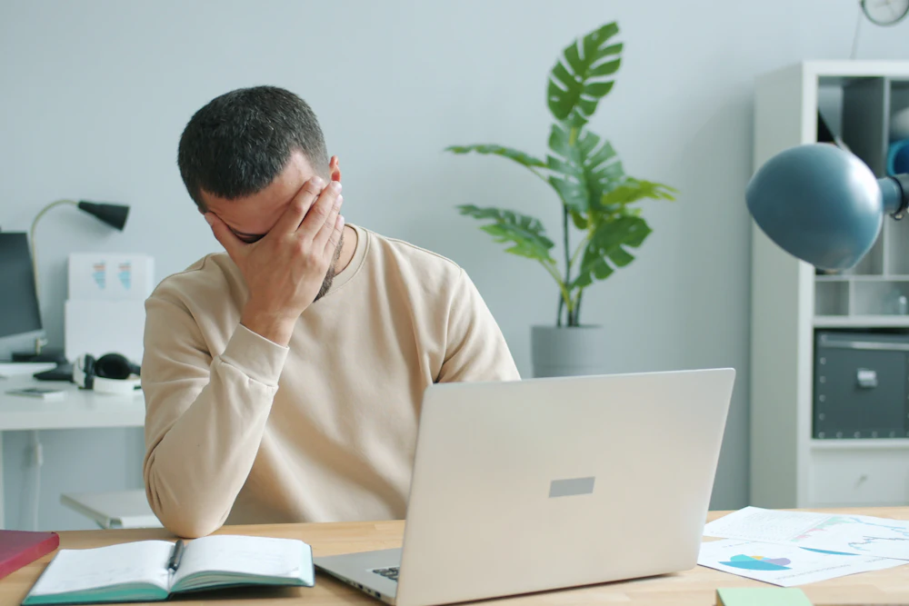 Man in his forties looking stressed while working at his laptop